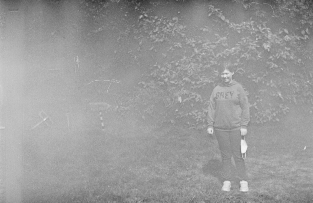 Schwarz weiße Fotografie von einem Mensch vor Gebüsch