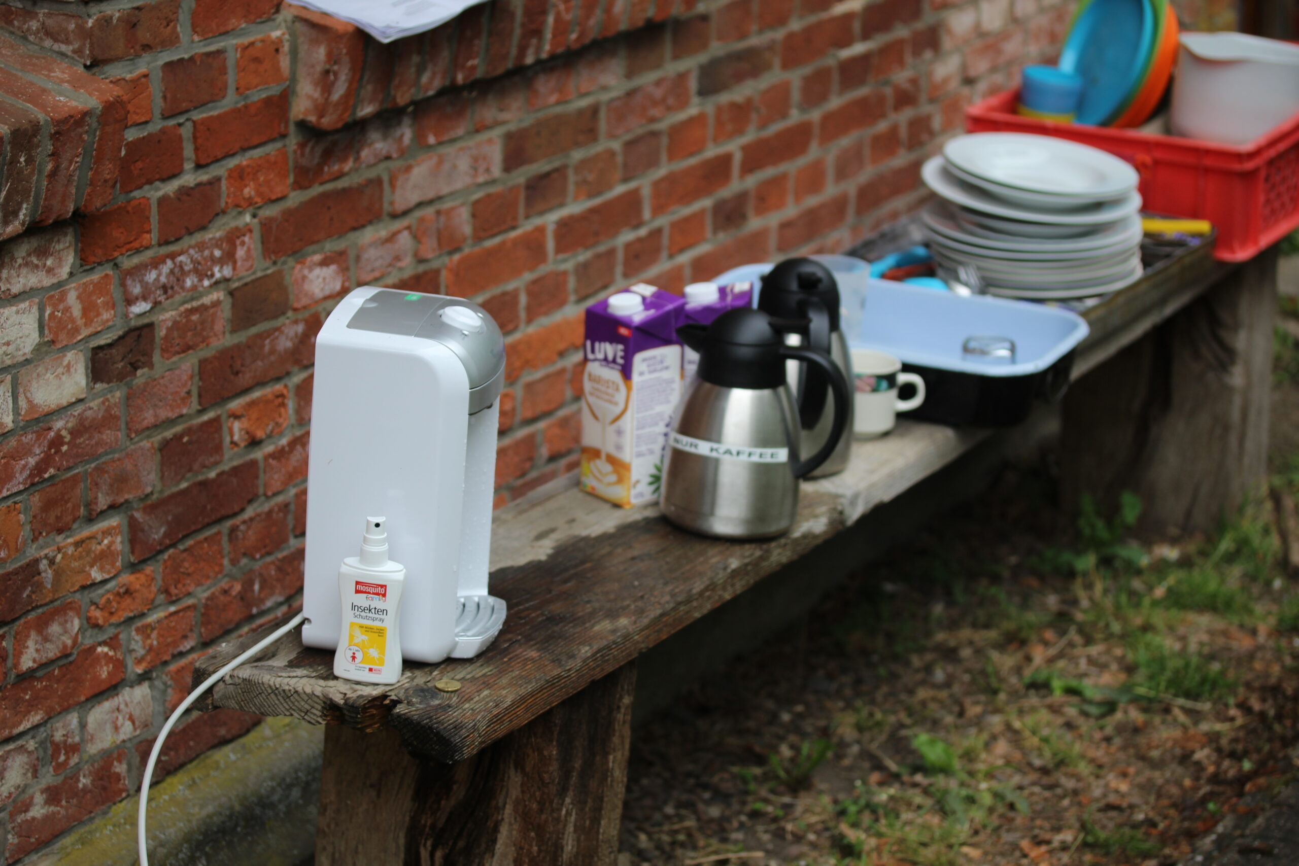Geschirr und Kaffeekanne auf einer Bank
